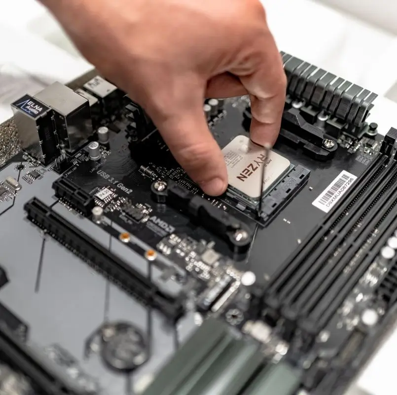 A technician installing a new AMD Ryzen processor into a motherboard for a custom gaming PC build at New Ross PC Repairs.