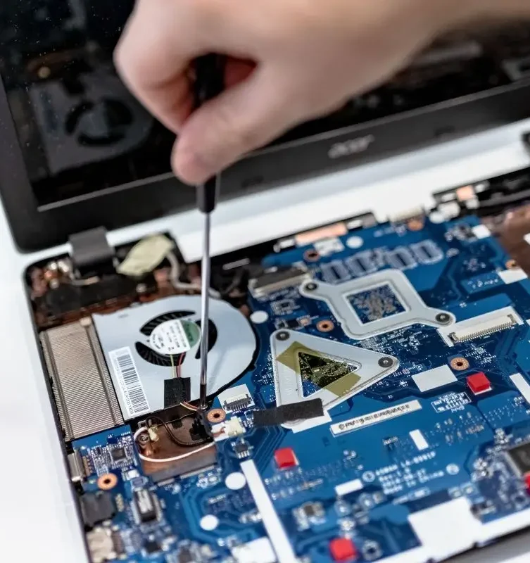 A technician using a screwdriver to repair the internal hardware and motherboard of a laptop at New Ross PC Repairs.